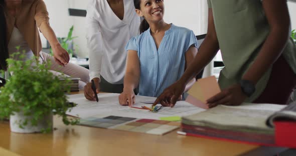 Midsection of group of happy diverse businesswomen working together in office