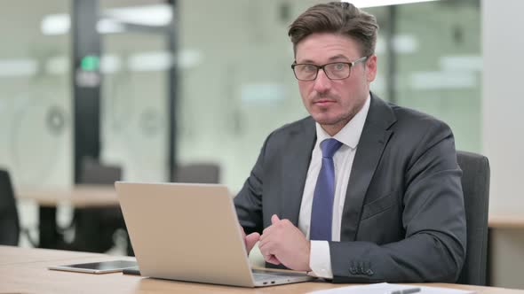 Middle Aged Businessman with Laptop Showing No Sign By Head Shake