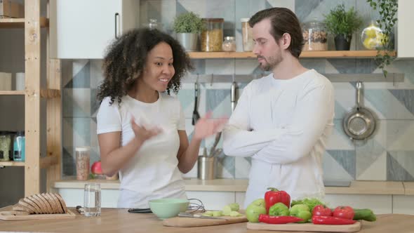 Young African Woman Arguing with Young Man in Kitchen