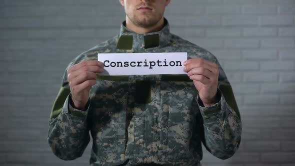 Conscription Word Written on Sign in Male Soldier Hands, Military Service, Duty