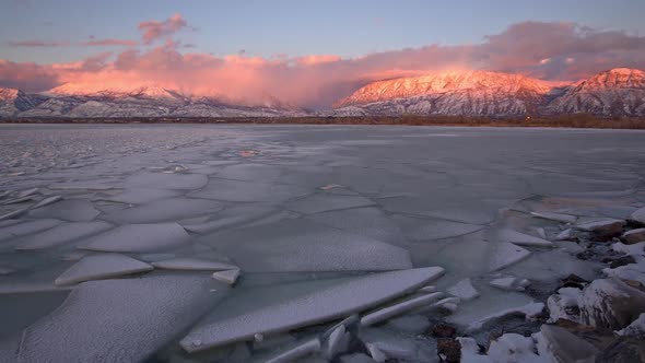 Panning view of broken ice on lake in winter during sunset