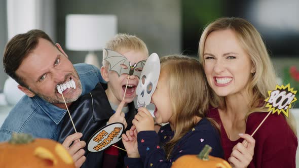 Portrait of playful family with masks during hallowee