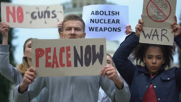 Activists Waving Banners Protesting Against Mass Shootings, Nuclear Weapon, War