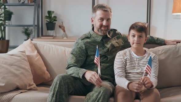 Army Officer and his Son Holding American Flags