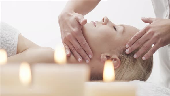 Young, healthy and beautiful woman gets massage therapy in the spa salon.