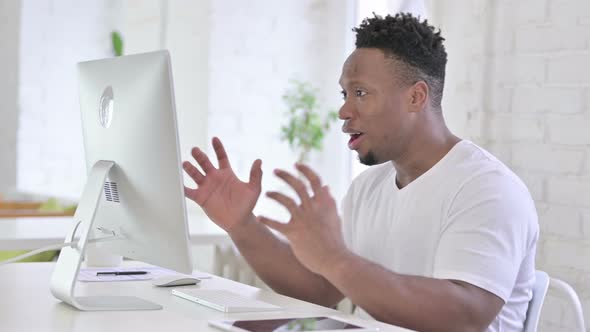 Shocked Casual African Man Reacting To Failure on Desktop