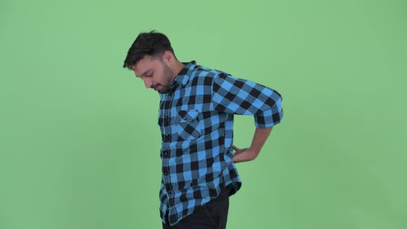 Stressed Young Bearded Persian Hipster Man Having Back Pain