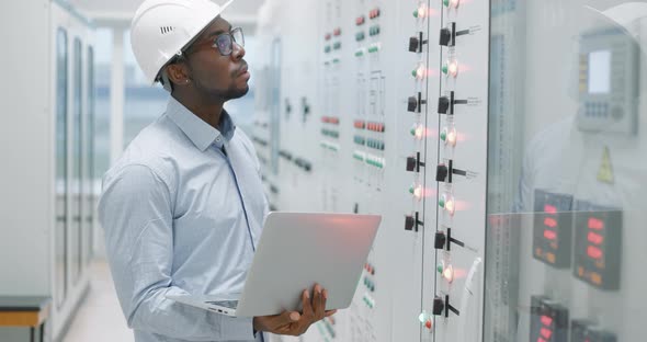 Man Using a Laptop While Working in a Server Room