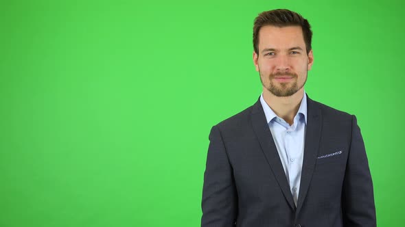 A Businessman Smiles at the Camera, Then Walks Away, Leaving the Frame on the Right - Green Screen