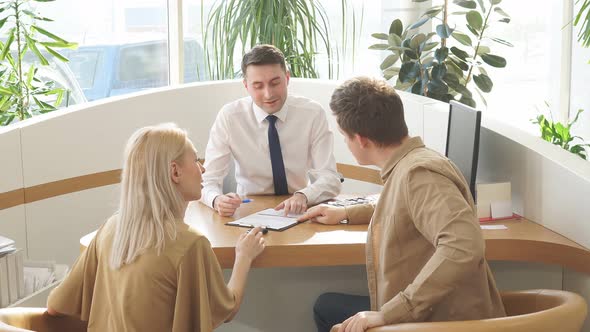 Helpful Consultant Have Conversation with Customers at Table.