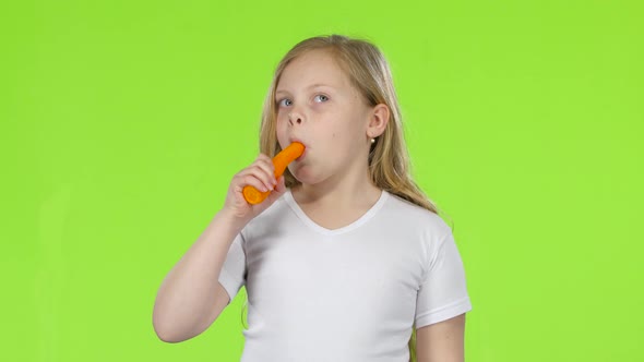 Little Girl Eats a Carrot and Shows a Thumbs Up. Green Screen