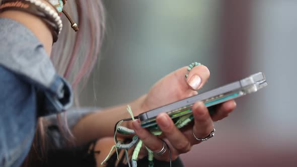 High school teen sitting on steps swiping through phone