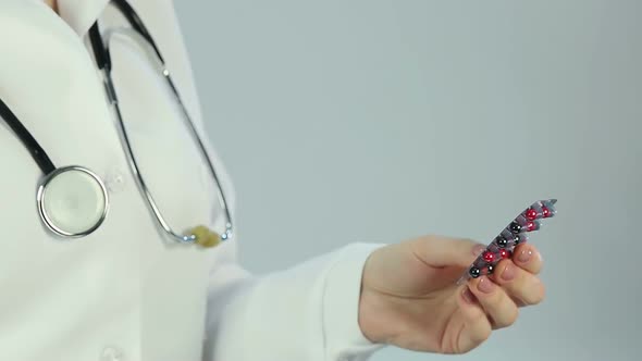 Scientist looking at pills through magnifier, studying pharmaceutical product