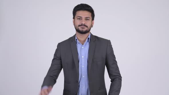 Young Handsome Bearded Indian Businessman Waving Hand