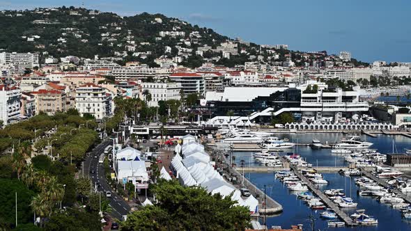 View of the sea port of Cannes, France. Moored yachts, buildings, greenery, Mediterranean sea