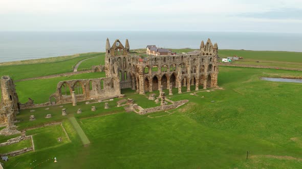 Ruin Structure Of Whitby Abbey With Scenic View Of North Sea In North Yorkshire, England. - aerial f