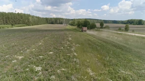 Aerial view of A truck is driving across the field and is approaching the harvesters 43