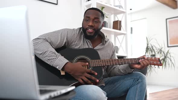 An African American Guy is Playing Guitar
