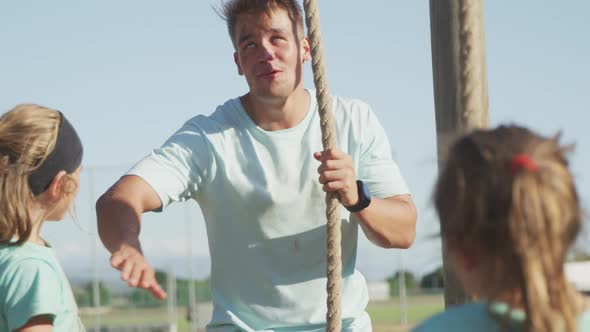 Caucasian coach instructing kids at boot camp