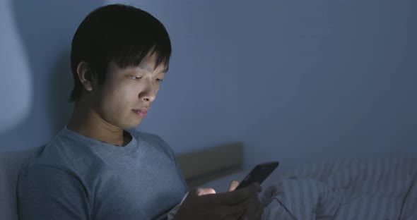 Man Use of Cellphone on Bed