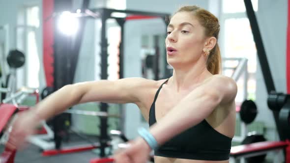 Athletic Girl Does a Warmup Before Training in the Gym