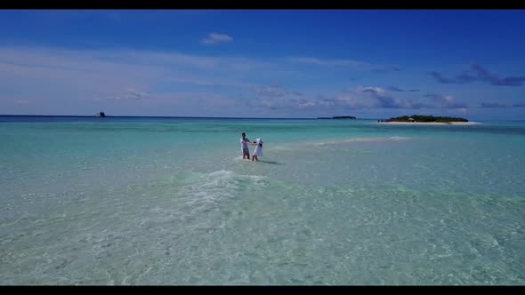Young couple happy together on tropical bay beach voyage by blue ocean and white sand background of 