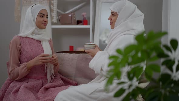 Happy Confident Muslim Women in White Hijabs Talking Drinking Morning Coffee on Wedding Day