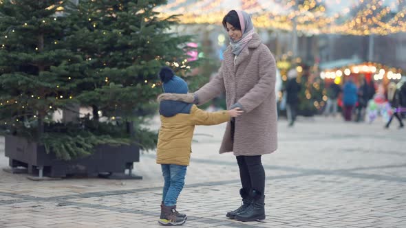 Wide Shot Joyful Middle Eastern Mother and Son Dancing in Slow Motion Outdoors on New Year's Eve