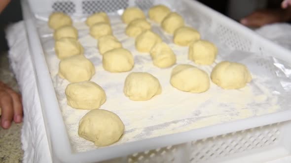 children's hands put dough balls on a stand to make Italian panzerotti pies