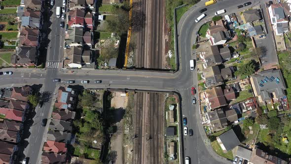 Pan up drone shot of train tracks passing through row housing suburban London Croydon