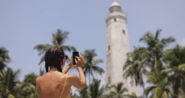Woman Traveler in Front of Famous Landmark of Sri Lanka with Smartphone Dondra Lighthouse
