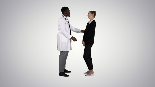 Doctor telling good news to a patient on gradient background.