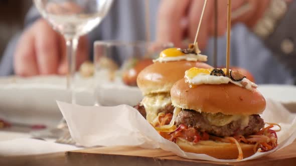 Close-up of gourmet burgers on a restaurant table as patrons eat their meal