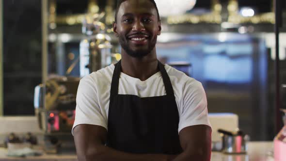 Portrait of african american barista smiling to camera wearing apron in cafe