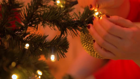 Woman Decorating Christmas Tree with Ball