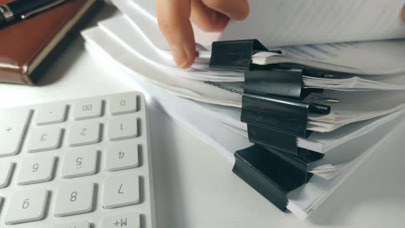Front View of a Businessman Hand Searching Documents Files or Information in Stack of Financial