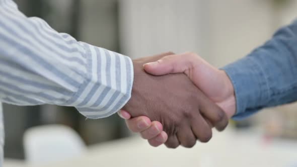 Close Up of African Man Shaking Hands with White Man