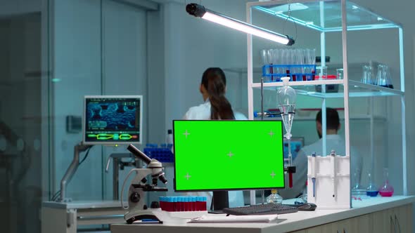 Chemists Working in Background of Lab Using Pc with Green Screen alt