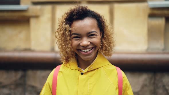 Slow Motion Portrait of Happy African American Woman with Curly Hair Looking at Camera and Smiling