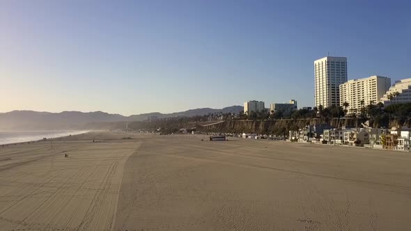 Empty beach, lonely walking during sunset.Smooth aerial view flight fly backwards drone footageat