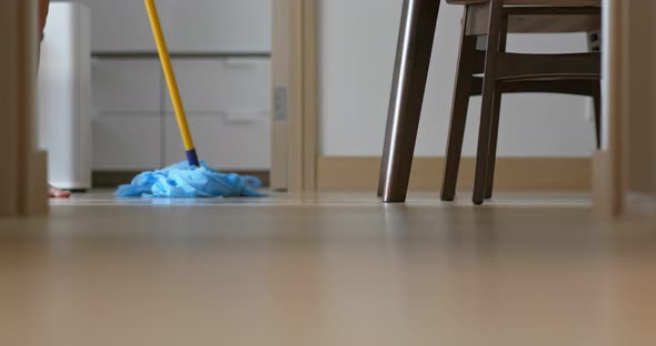 Housewife clean the floor with mop