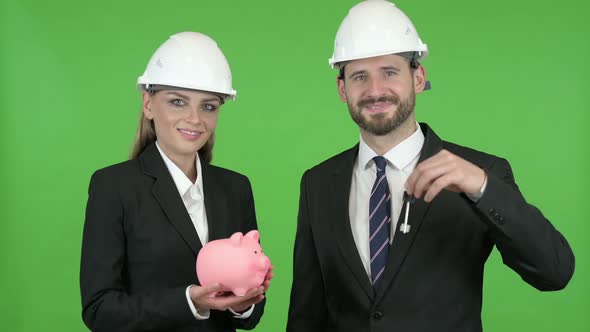 Engineers Posing with Piggy Bank and Construction Equipment Against Chroma Key