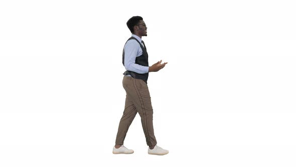 Young African American Businessman Gesturing and Talking To Camera While Walking on White Background