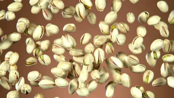 Super Slow Motion Shot of Flying Pistachios After Being Exploded on Brown Background at 1000Fps