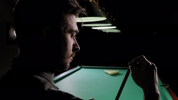 Closeup of a Man Rubbing a Cue with Chalk in a Bar Before Playing Billiards