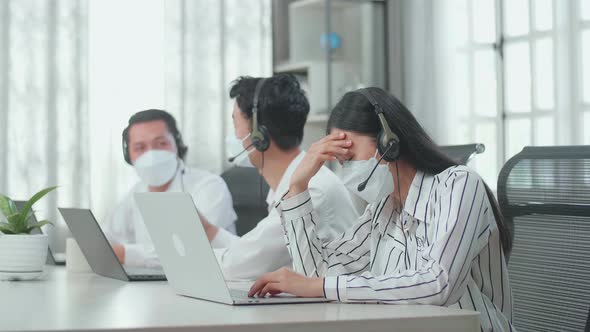 Woman Of Three Call Centre Agents Wearing Mask, Headache Because Colleagues Talking With Each Other