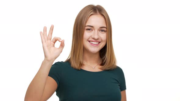 Portrait of Attractive Adult Female with Brown Flowing Hair Demonstrating Alright Symbol with