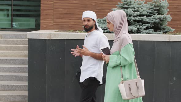 Muslim Couple Walking by Office Building