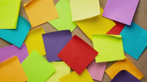 Colorful blank sticky notes being dropped onto canvas board