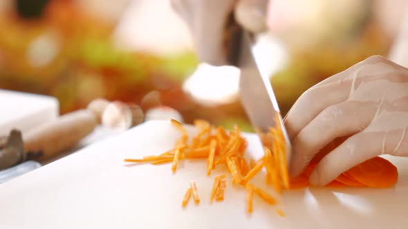 Hand with Knife Cutting Carrot.
